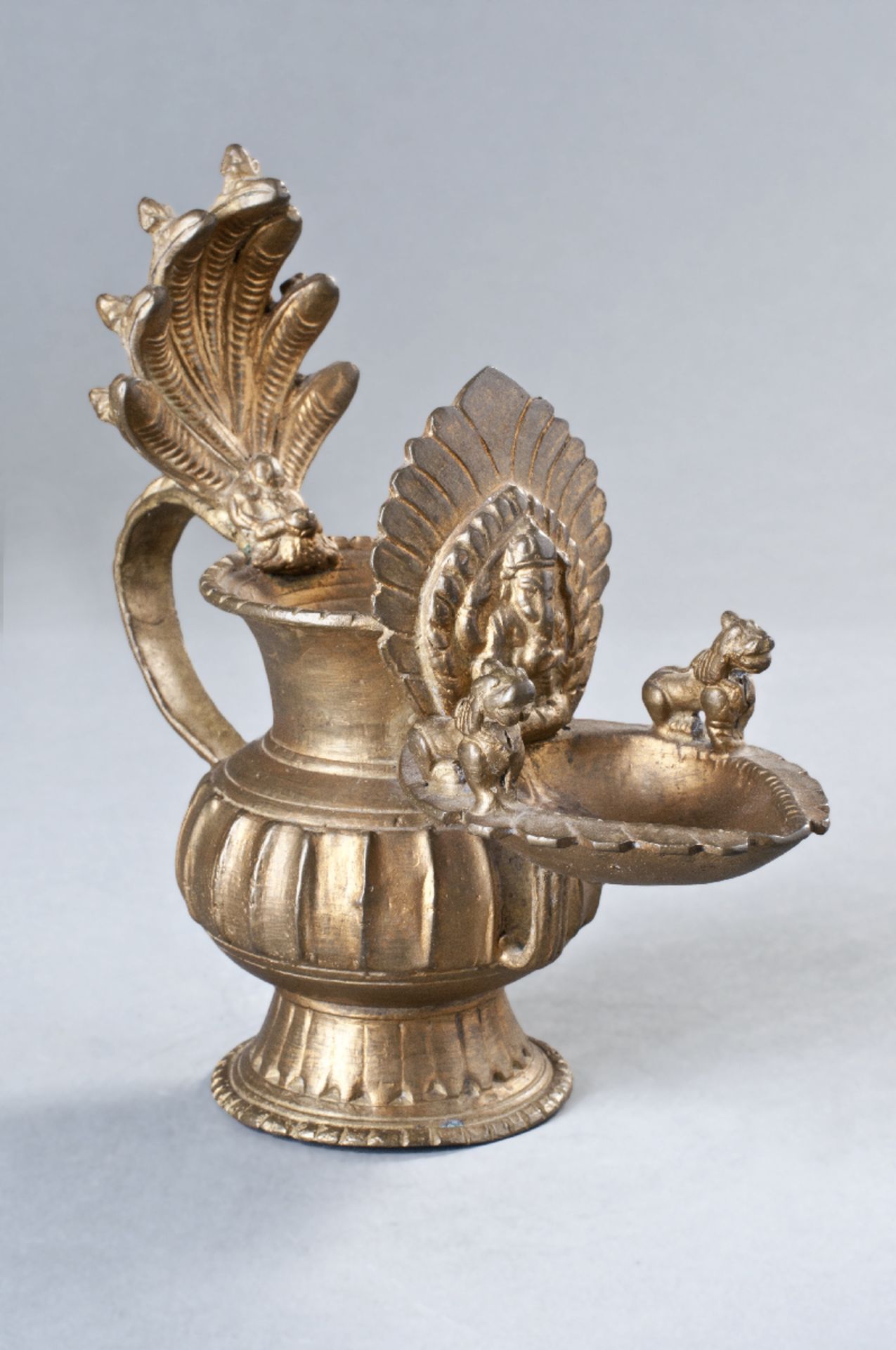 DEKORATIVES GEFÄß MIT NAGA
Bronze mit Lackvergoldung, Nepal, 20. Jh.Ausgestellter Fuß mit