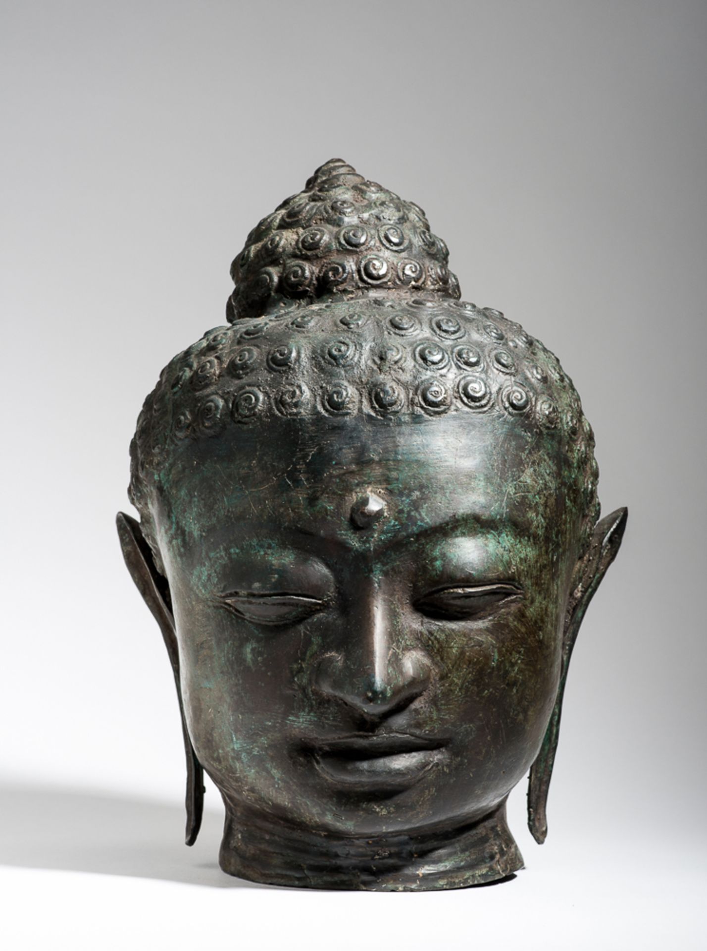 KOPF EINES BUDDHA IM KLASSISCHEN STIL
Bronze. Thailand, 20. Jh.Das Gesicht mit einem schönen