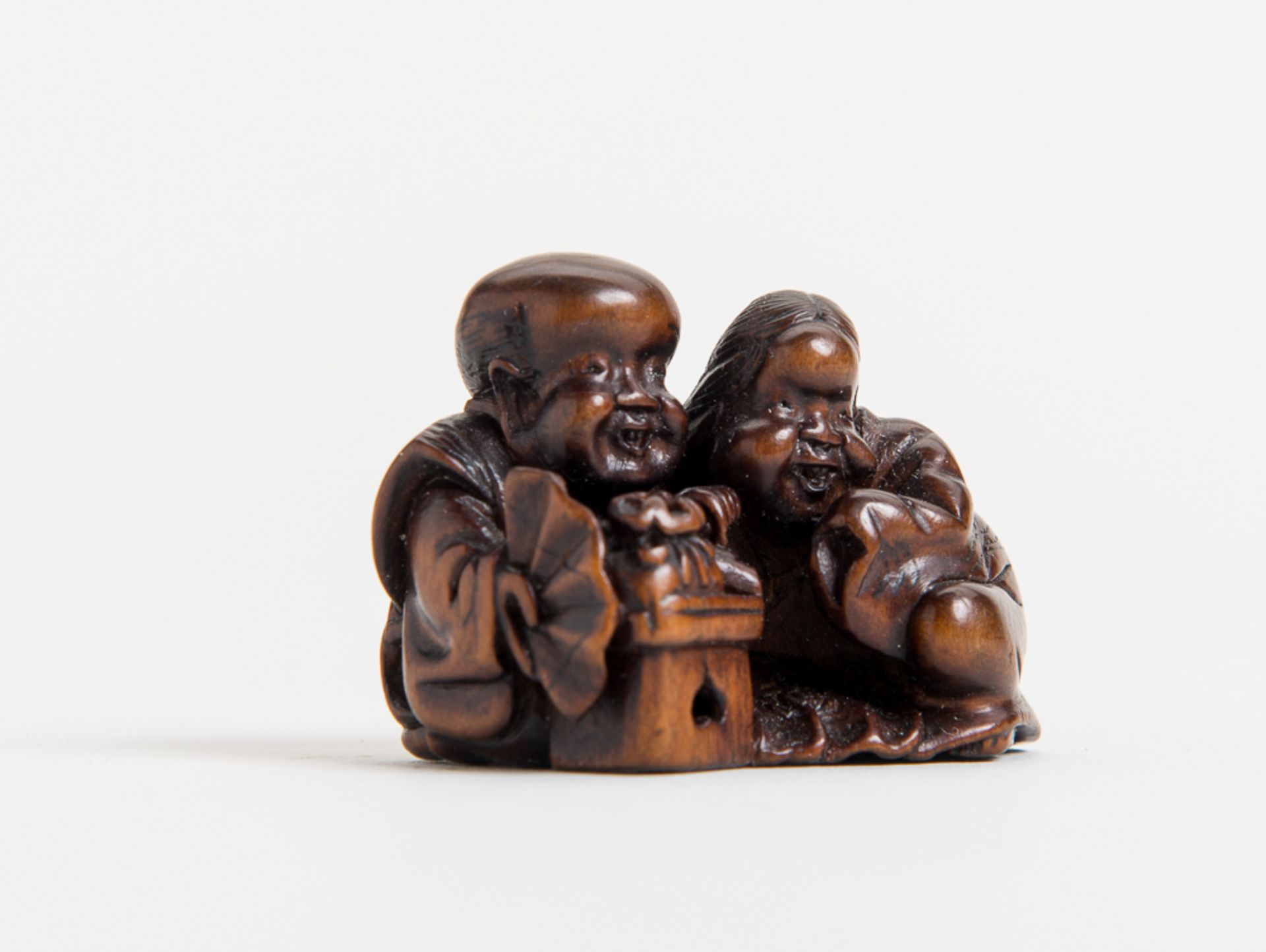 GLÜCKSZWERG FUKUSUKE MIT DER OKAME
Netsuke, Holz. Japan, 19. Jh.Sehr gut gearbeitetes Netsuke, das - Image 2 of 4