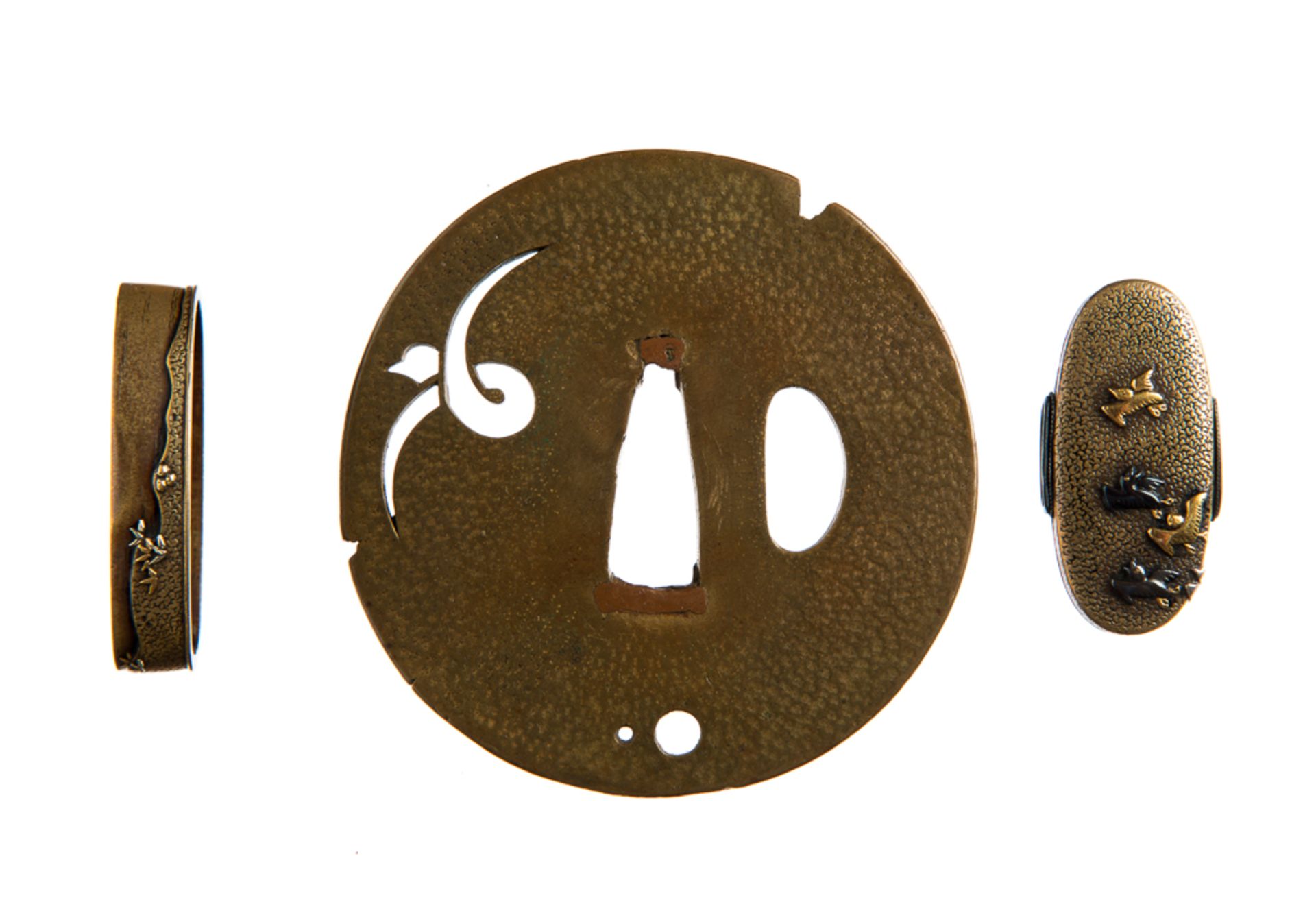 TSUBA UND FUCHI-KASHIRA
Sentoku und Gold. Japan, 19. Jh.Sehr feine Arbeit! Das ovalrunde Tsuba mit