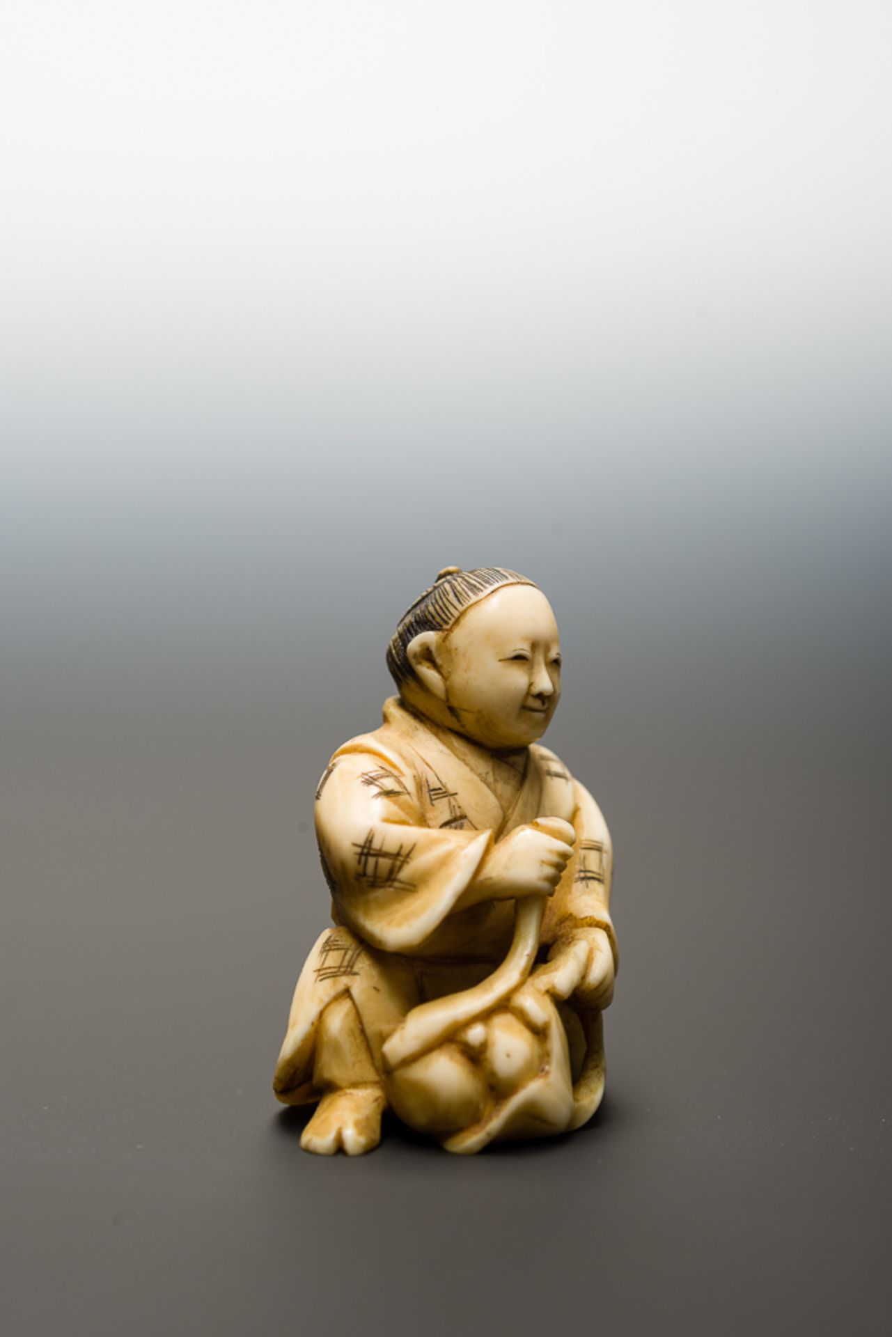 MANN MIT FRÜCHTEN
Netsuke-Okimono, Elfenbein. Japan, Meiji-ZeitHalb knieender Mann, der aus seinem - Bild 5 aus 6