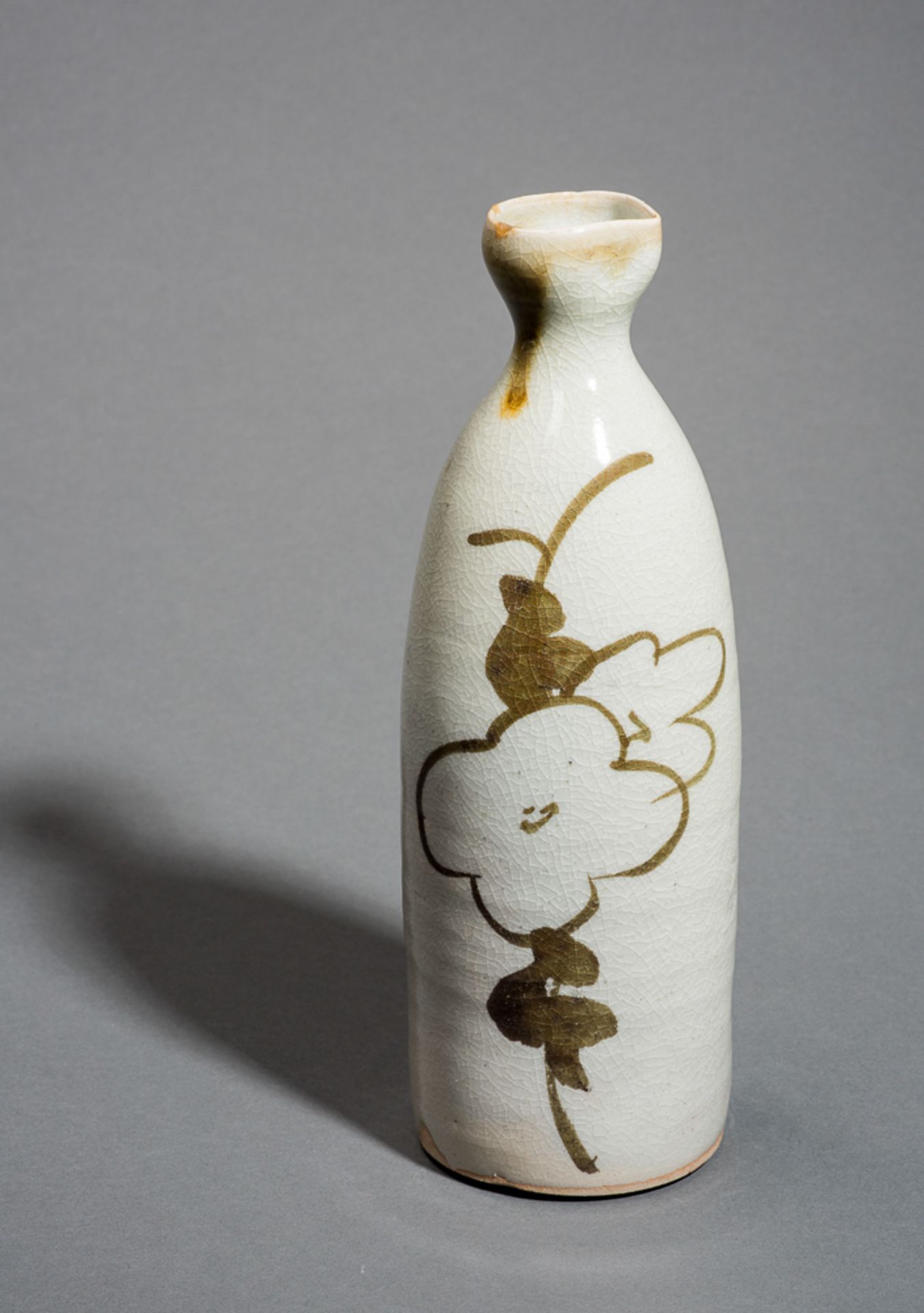 SAKEFLASCHE 
Keramik. Japan, 19./ 20. Jh.Glasiert in Beige mit Craquelé. Auf einer Seite Blütendekor