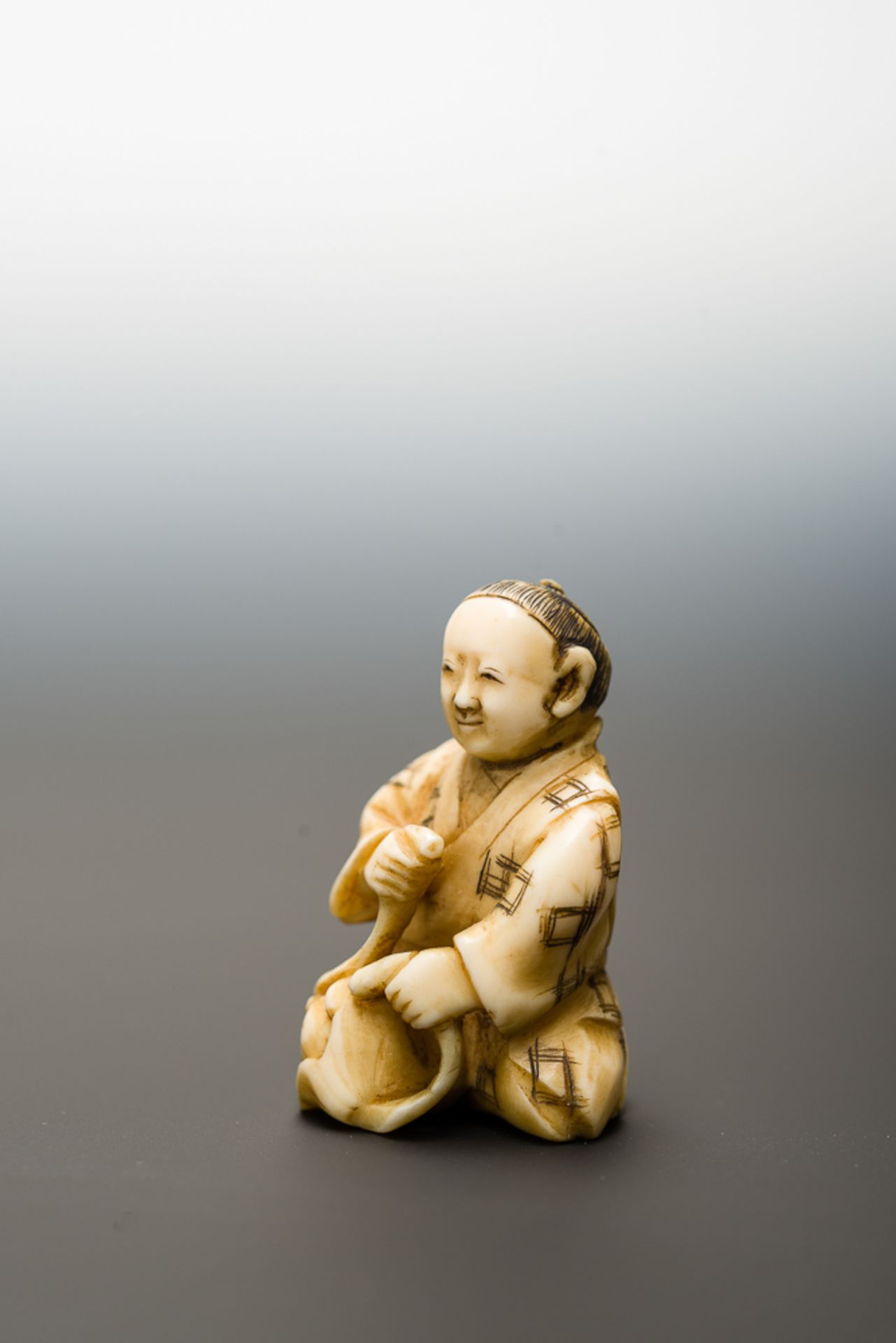 MANN MIT FRÜCHTEN
Netsuke-Okimono, Elfenbein. Japan, Meiji-ZeitHalb knieender Mann, der aus seinem - Bild 3 aus 6