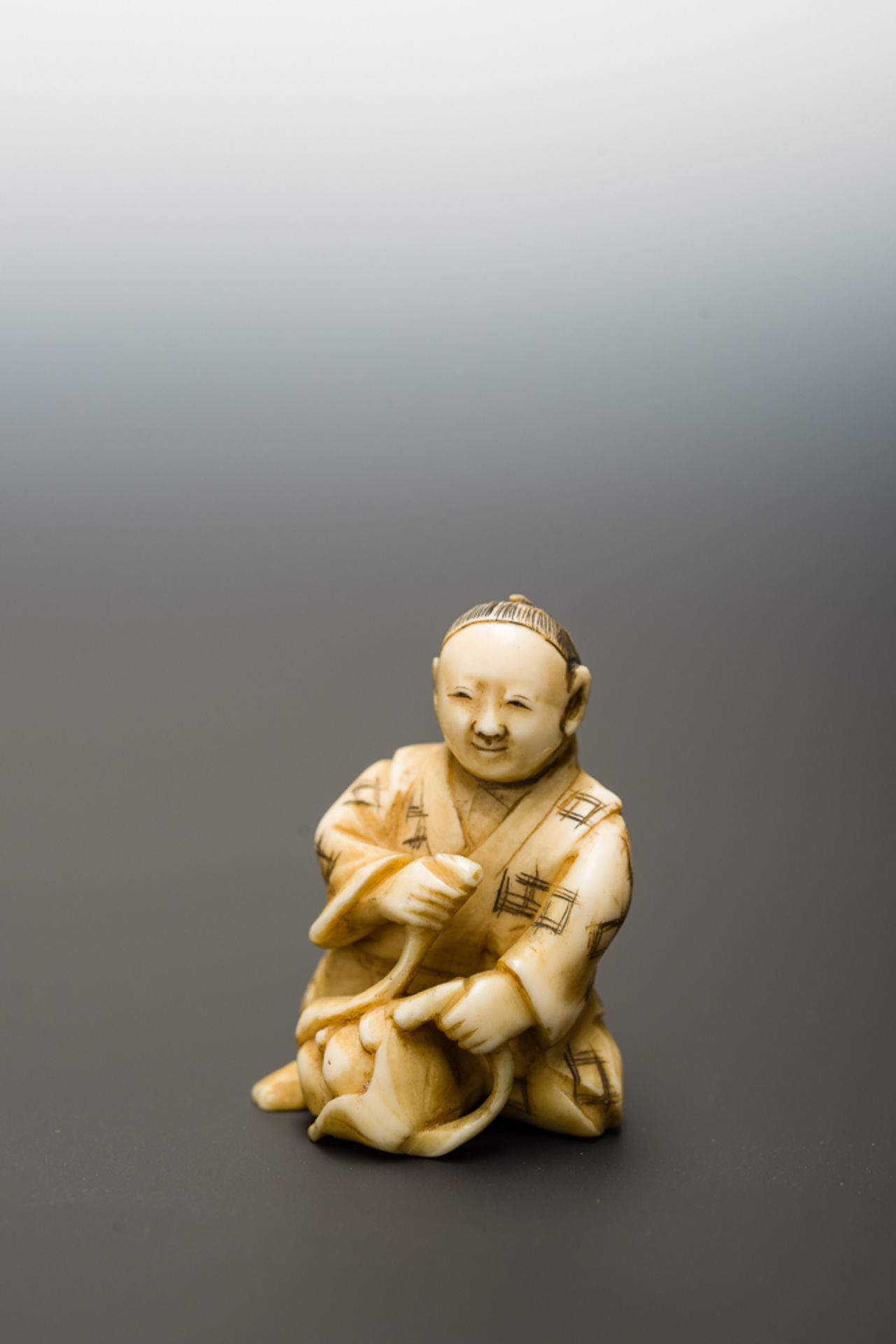MANN MIT FRÜCHTEN
Netsuke-Okimono, Elfenbein. Japan, Meiji-ZeitHalb knieender Mann, der aus seinem - Bild 2 aus 6
