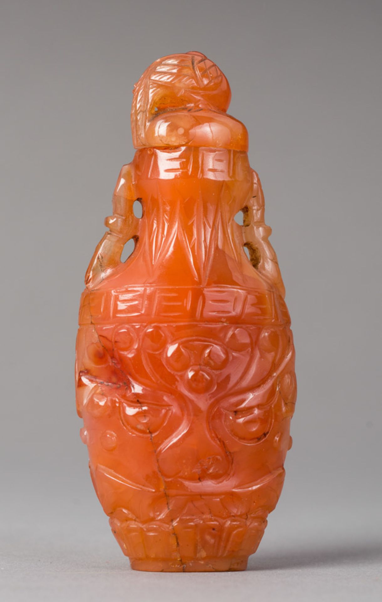 SNUFFBOTTLE MIT SCHNITZDEKOR
Karneol. Qing bis Republik, 19. bis ca.1. Drittel 20. Jh.HÖHE 9 CMAus