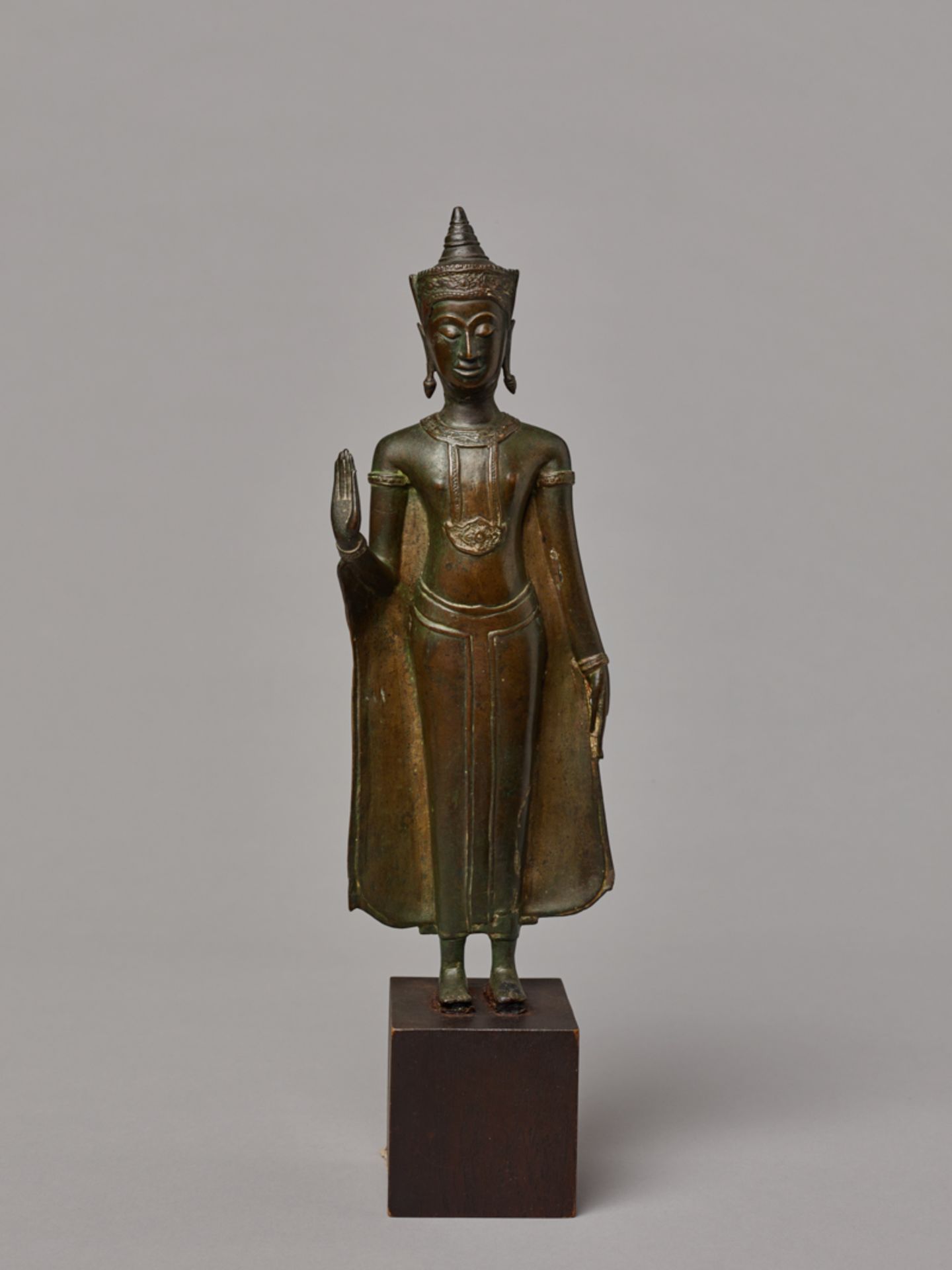 STEHENDER GEKRÖNTER BUDDHA
Gelbe Bronze. Thailand, Königreich Ayutthya, ca. 17. Jh.Eine fein