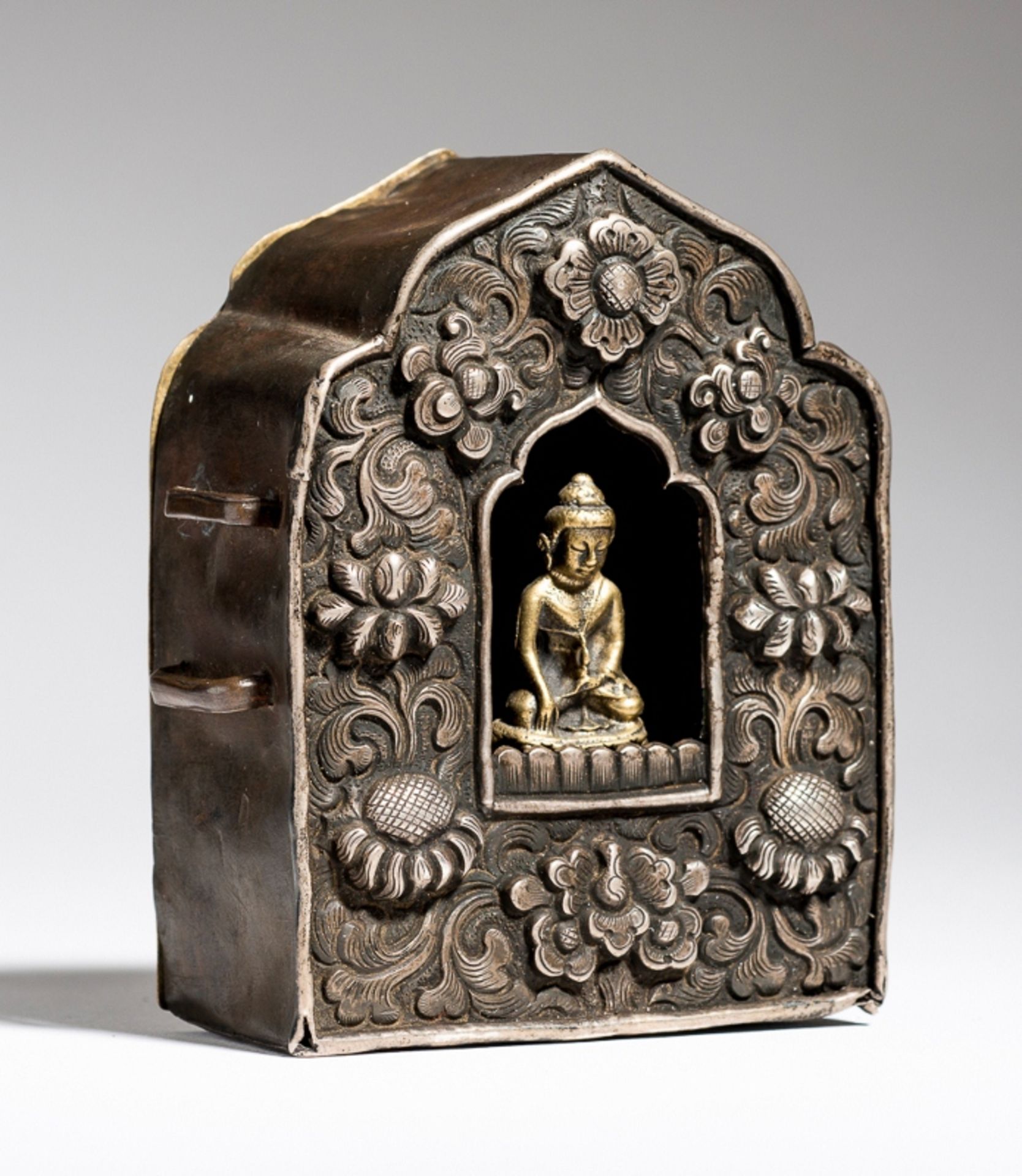 GAU MIT BUDDHA MARAVIJAYA
Silber-Repoussé und gelbe Bronze. Tibet, 19. Jh.Amulettbehälter Gau mit