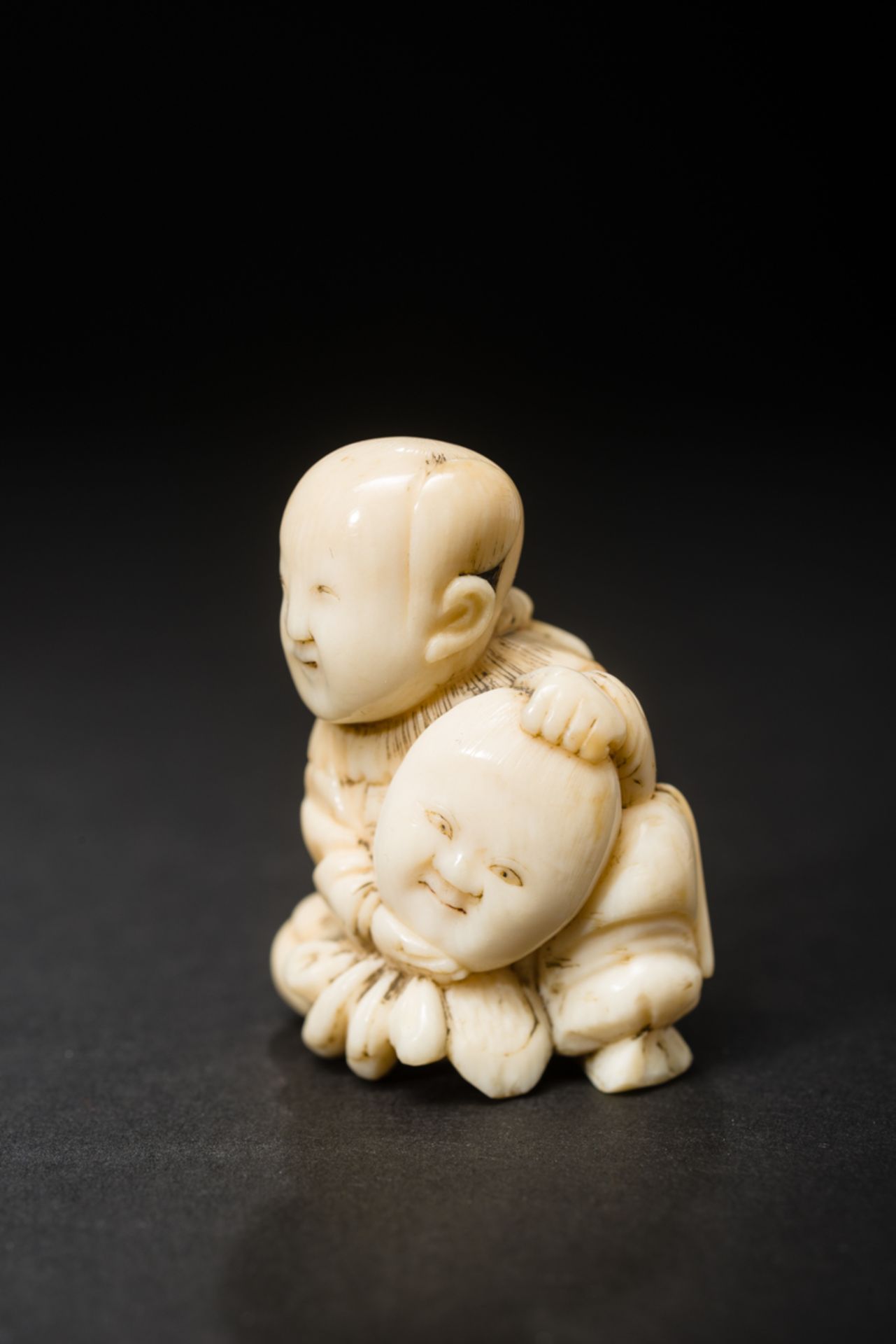 KARAKO-KNABE MIT MASKE
Netsuke, Elfenbein. Japan, 19. Jh.Am Boden sitzender Karako, ein chinesisch - Image 5 of 6