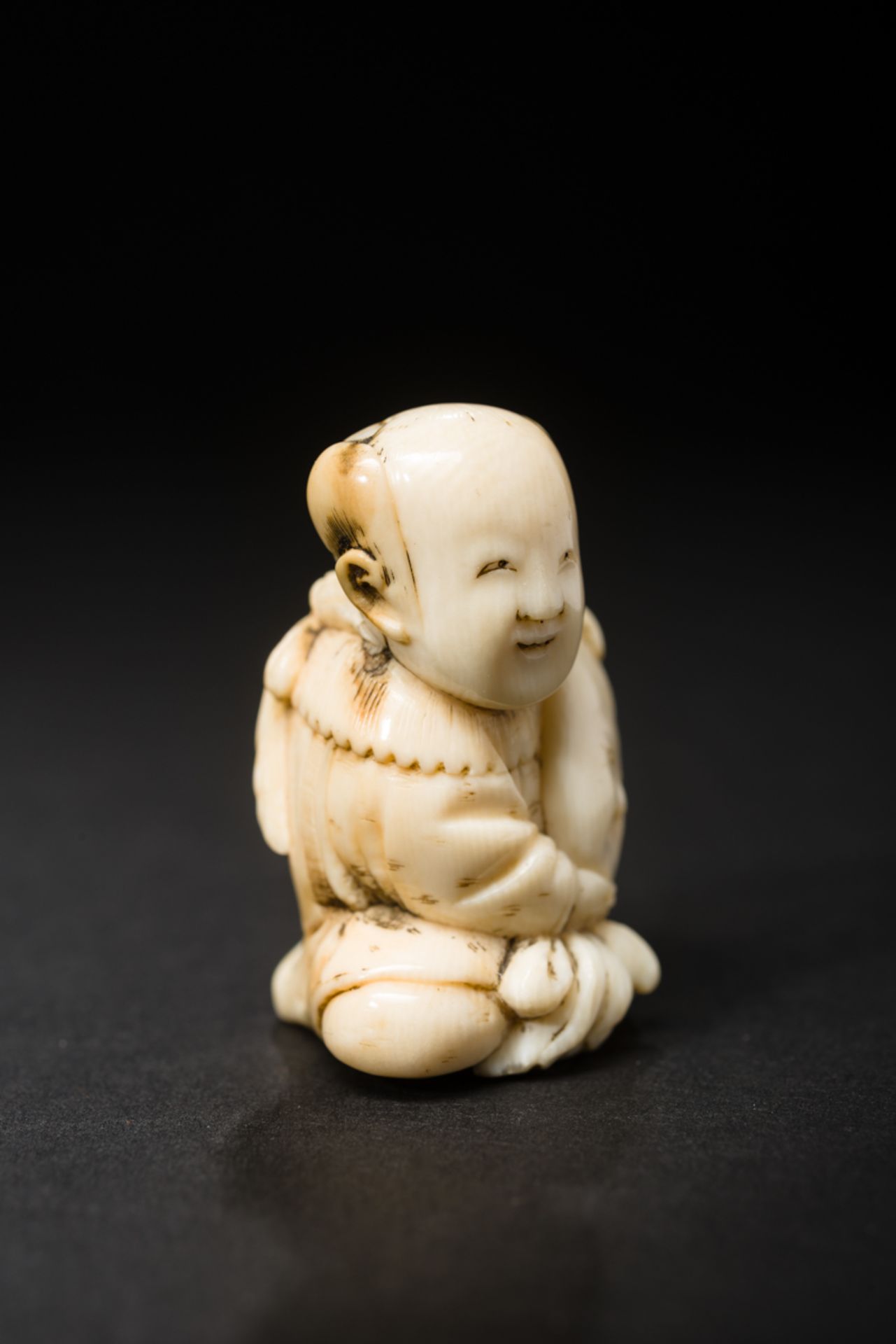 KARAKO-KNABE MIT MASKE
Netsuke, Elfenbein. Japan, 19. Jh.Am Boden sitzender Karako, ein chinesisch - Image 3 of 6