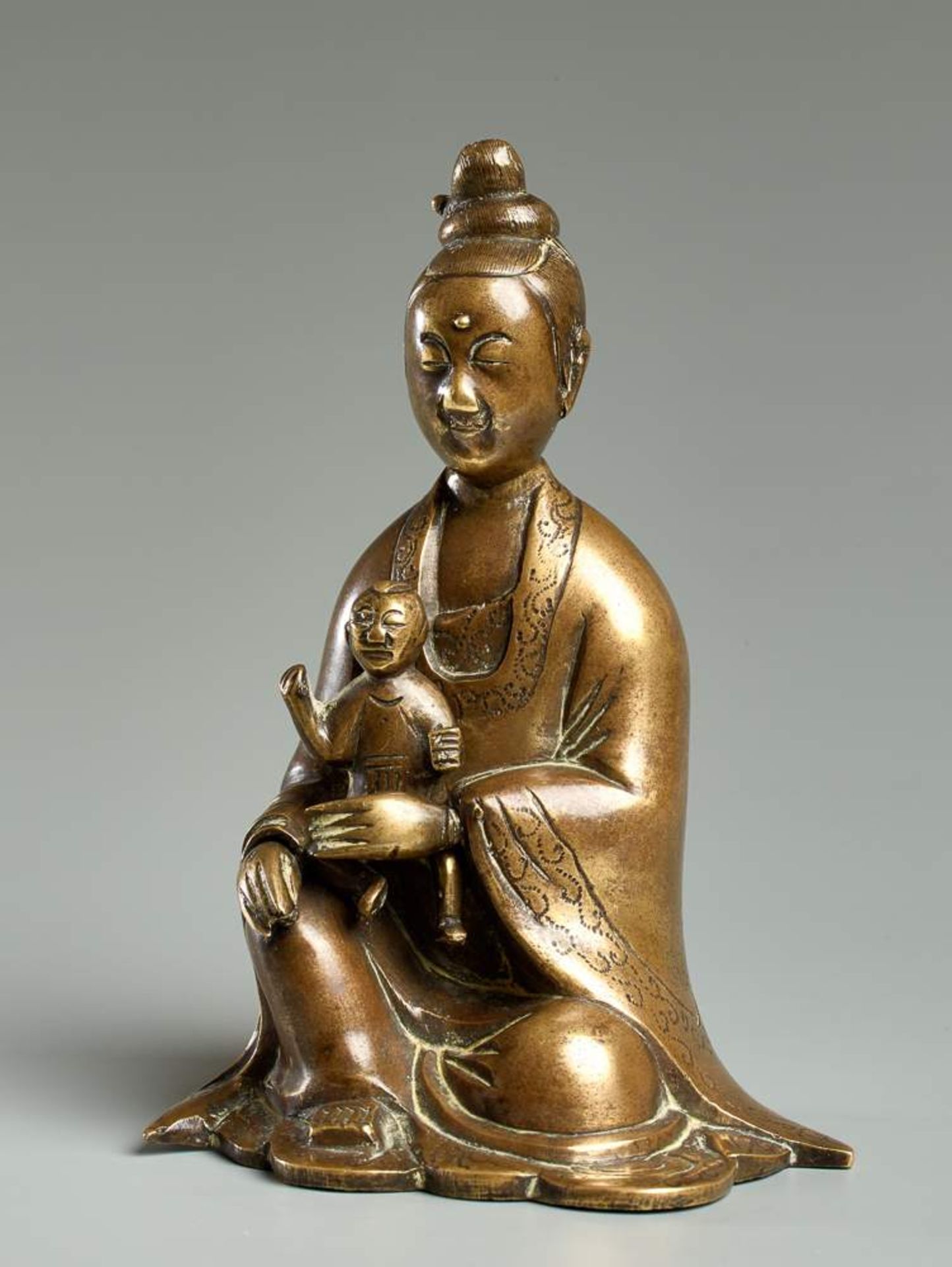 DIE GÖTTIN GUANYIN MIT KIND
Gelbe Bronze. China, 18. Jh.Sie dürfte die beliebteste „Gottheit“ Chinas