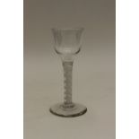 An 18th century wine glass, the plain ogee bowl on a multi series opaque twist stem with double
