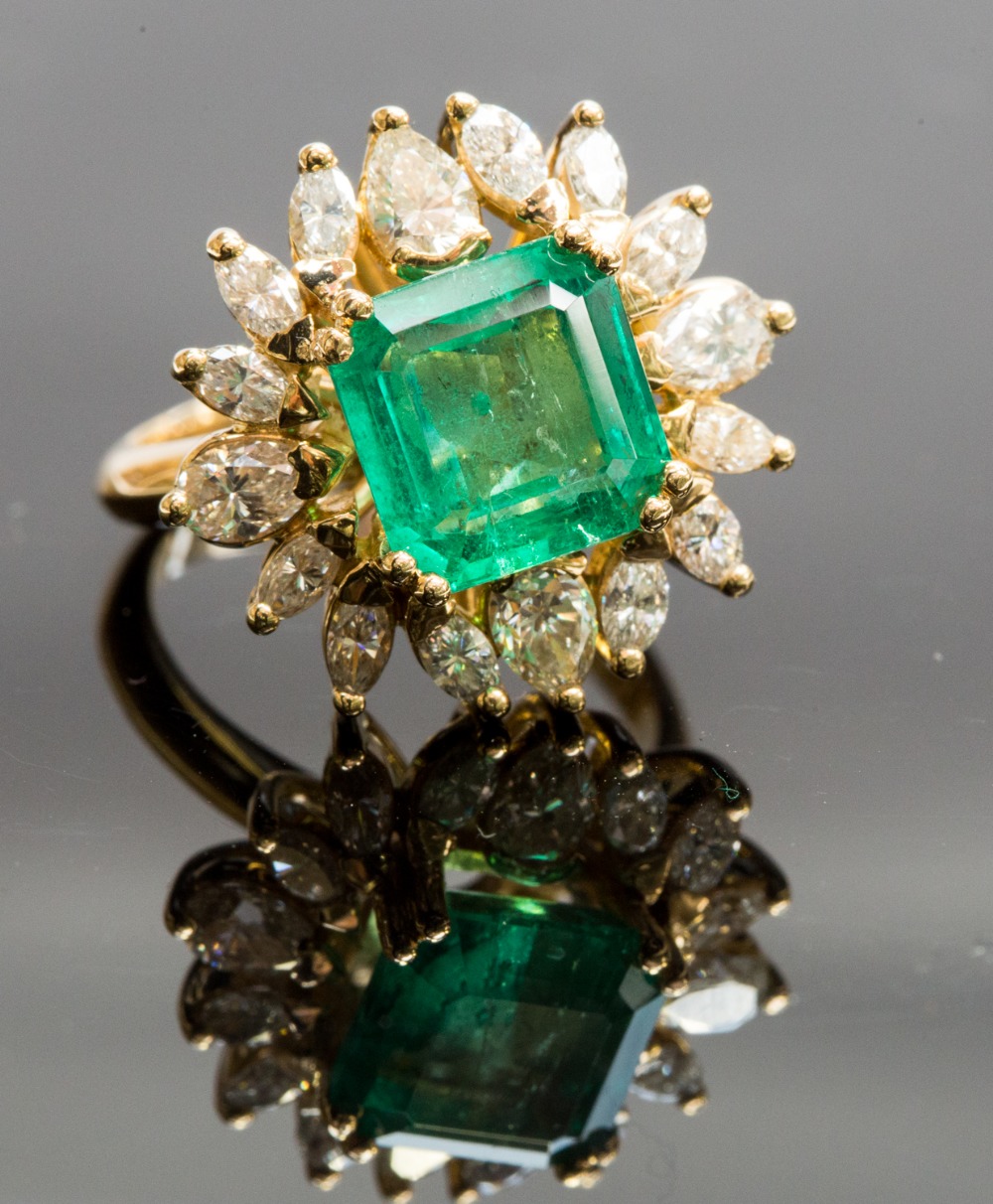 An 18ct yellow gold, emerald and diamond cluster ring, the central square-cut emerald approx 5cts,