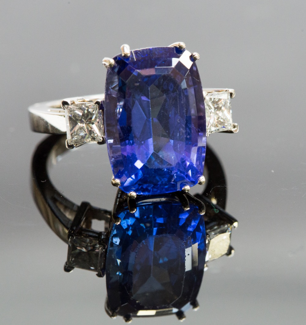 A 14k white gold, tanzanite and diamond ring, the claw-set tanzanite approx 12ct, flanked by two