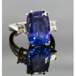 A 14k white gold, tanzanite and diamond ring, the claw-set tanzanite approx 12ct, flanked by two