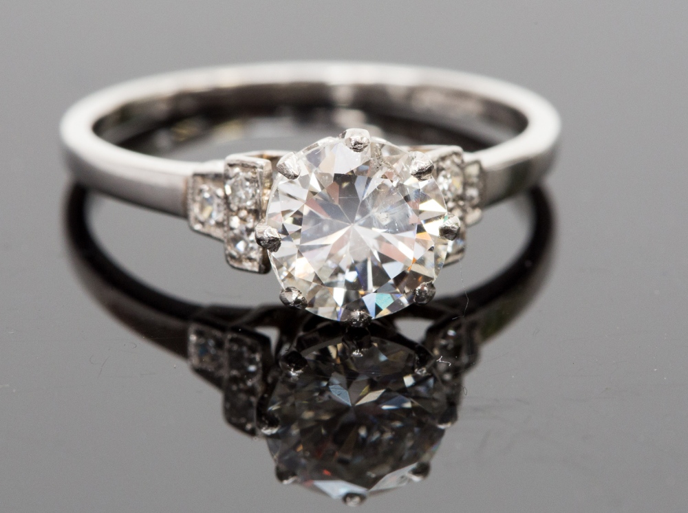 A platinum and diamond solitaire ring, the round brilliant cut stone approx 1.23ct, flanked by six