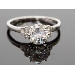A platinum and diamond solitaire ring, the round brilliant cut stone approx 1.23ct, flanked by six