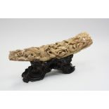 A carved ivory tusk on carved wooden stand, decorated with birds in flight, 28cm long