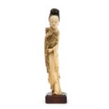 An Oriental carved ivory figure of a woman holding a blossoming branch, probably Chinese, 19th