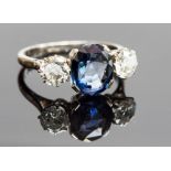 An platinum, sapphire and diamond three-stone ring, the central oval cut sapphire approx 2.70cts,