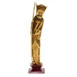 A large Oriental ivory figure of a warrior in bamboo armour, holding a spear and sword, stained,