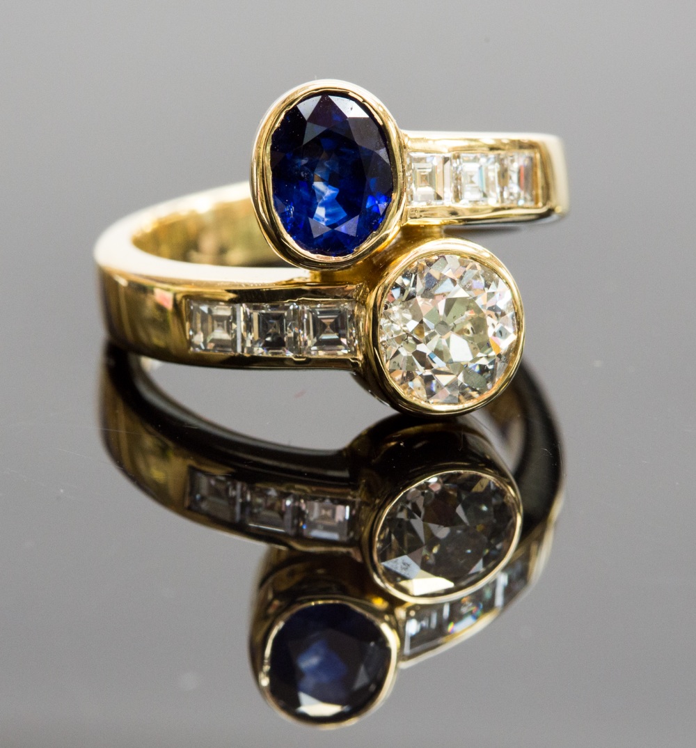 A sapphire and diamond two-stone twist ring, centre diamond approx 1.60cts, opposite an oval-cut