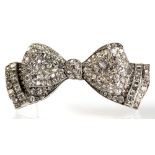 A platinum and diamond bow brooch, set with graduated round-cut and step-cut stones, 5.5cm wide,