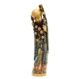 A 19th century ivory tusk carving of an immortal holding a flowering branch, with coloured