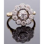 An 18ct gold and diamond cluster ring, the central round brilliant-cut stone surrounded by ten