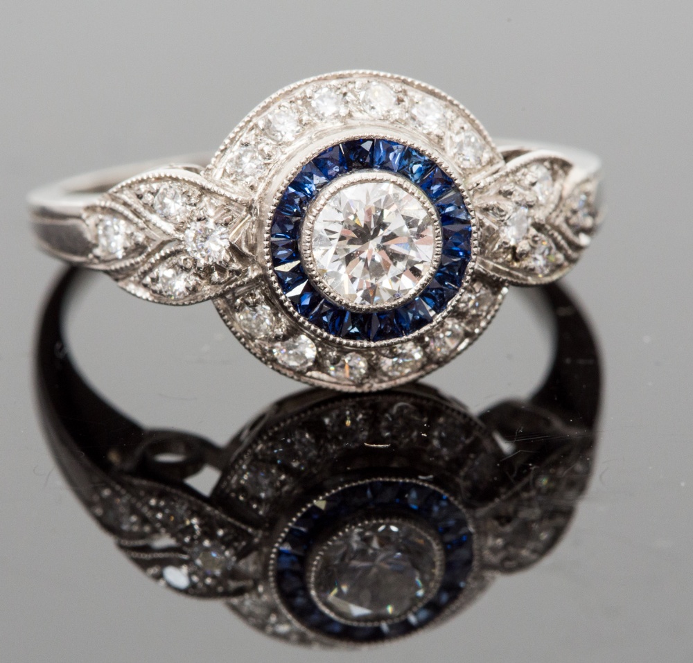 An Art Deco style platinum, sapphire and diamond ring, the central round brilliant-cut stone approx