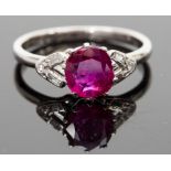 A platinum, ruby and diamond ring, the cushion-cut ruby approx 1.54ct, flanked by baguette and round