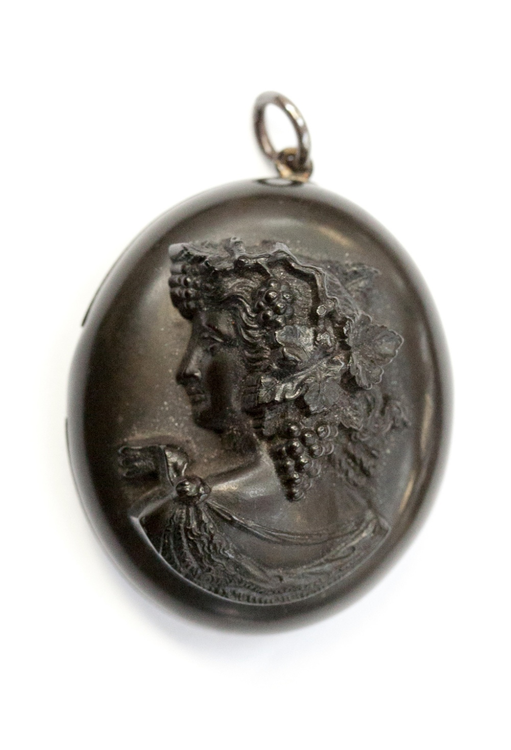 A 19th century jet cameo locket, carved in high relief depicting a Bacchant, the inside engraved