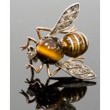 A novelty insect brooch, as a bee, set with a round cabachon tigers eye abdomen, enamelled thorax,