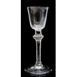 An 18th century wine glass, the round funnel bowl on a cushion knopped stem with angular inverted