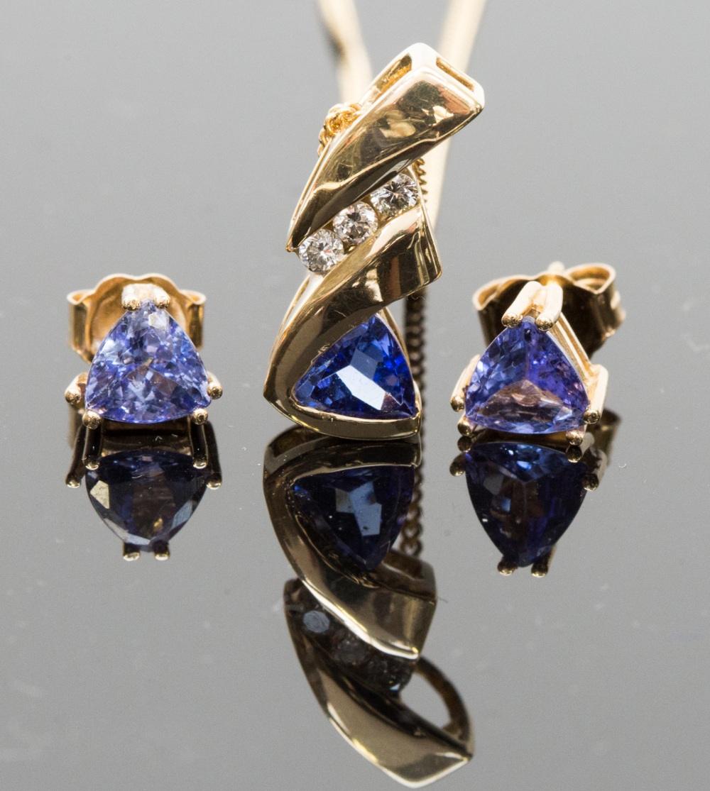 A tanzanite and diamond pendant, set with a triangular cut tanzanite below a row of three round