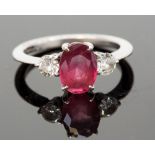 An 18ct gold, pink tourmaline and diamond three-stone ring, the central oval pink stone flanked by