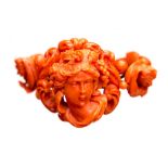 A 19th century coral bangle, carved depicting a bacchant, flanked by cherubs, 83.4 g approx