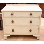 A white painted chest of drawers, fitted with three long drawers