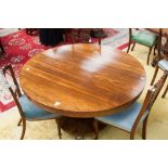 An early Victorian rosewood circular topped breakfast table, raised on a platform base, standing on