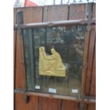 A metal cast plaque depicting middle ages figure holding a crown, sprayed with gold paint/leaf and