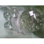 A large clear glass controlled bubbles paperweight with six smaller similar style paperweights (7)