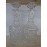 A pair of cut glass decanters with elaborately cut stopper and cylindrical bodies, with star cut