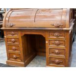 A late 19th century ash and maple veneered cylinder bureau, raised on a base with four drawers to