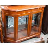 A contemporary mahogany veneered display cabinet, with bevelled glazing,