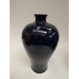 A dark blue glazed oriental baluster vase, scratched glaze