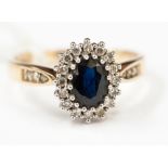 A 9ct gold ring, central large sapphire stone surrounded by small diamonds