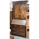 A 1920s oak bureau bookcase, the upper section fitted with two glazed doors, opening to reveal