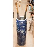 An oriental blue and white stick stand together with various umbrella stand walking stick