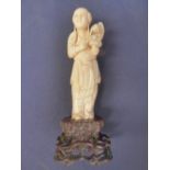 A Chinese ivory carving of a female immortal with a flower basket (wood stand)