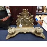 A late 19th century brass cast desk stand, fitted with two ink wells,