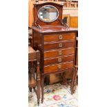 An Edwardian mahogany music cabinet, the top with an inset mirror to back, fitted with five drawers,